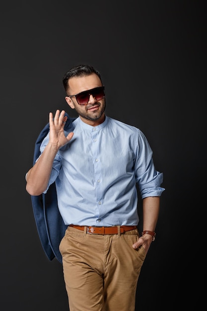 Bel homme sexy élégant en costume bleu sur fond noir. homme d'affaire