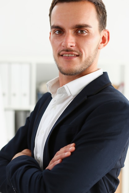 Bel homme souriant en costume stand in office