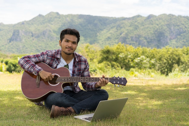 Bel homme souriant, jouant de la guitare