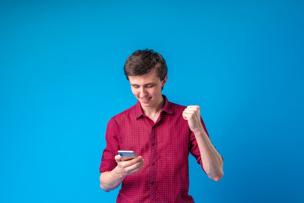 Bel homme souriant positif avec un téléphone mobile