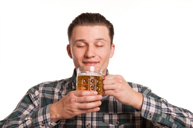 Bel homme souriant, les yeux fermés de plaisir, sentant la délicieuse bière isolée sur blanc. Homme joyeux célébrant l'Oktoberfest. Concept de restaurant, bar ou pub