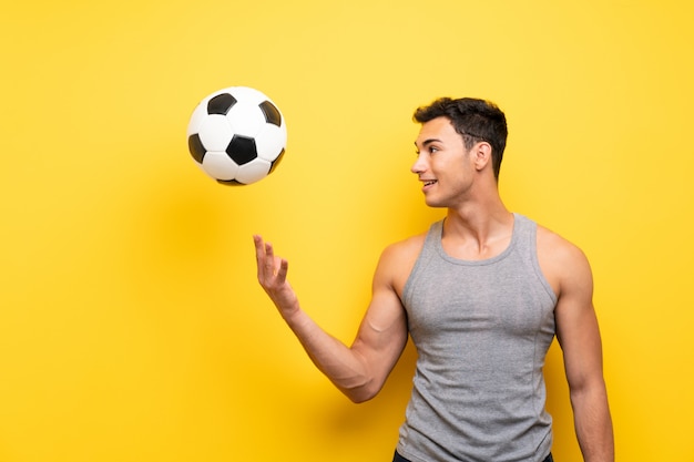 Bel homme sport sur fond isolé avec un ballon de foot