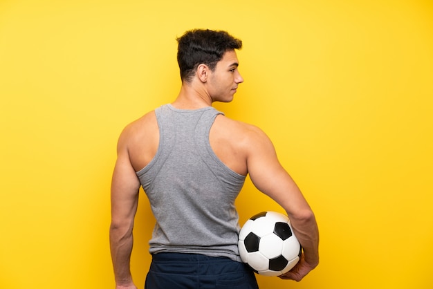 Bel homme sport isolé sur un ballon de foot