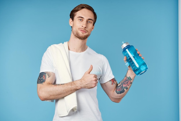 Bel homme en t-shirt blanc sport bouteille d'eau santé mode de vie d'entraînement