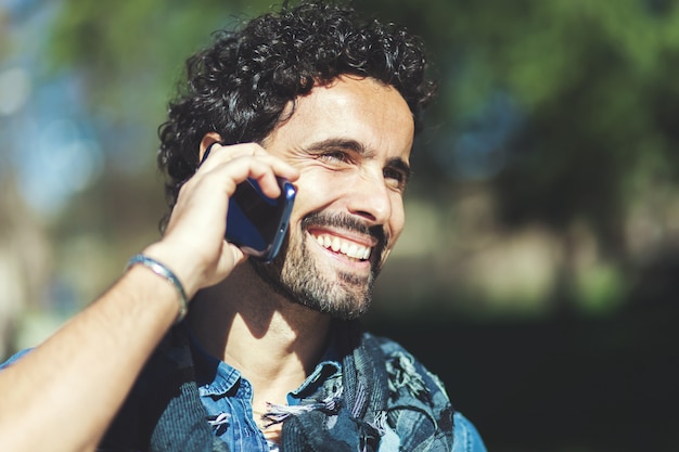 Bel homme téléphonant dans le parc