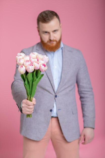 Bel homme tenant un bouquet de tulipes