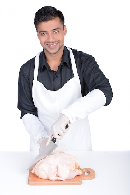 Bel homme tenant le poulet sur la table.