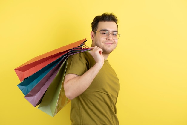 bel homme tenant des sacs à provisions colorés.