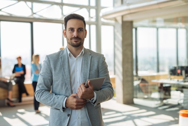 Bel homme tenant une tablette numérique dans un bureau