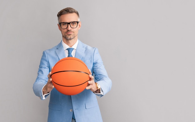 Bel homme tenir un ballon de basket sur fond gris, espace de copie, entreprise.