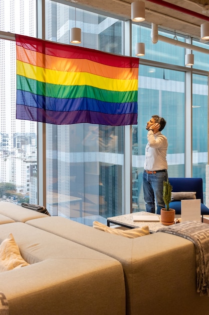 Bel homme en tenue décontractée, contemplant le drapeau représentant la communauté LGBT