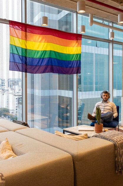 Bel homme en tenue décontractée, contemplant le drapeau représentant la communauté LGBT