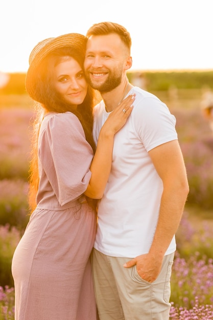 Un bel homme tient la main d'une belle femme et profite de moments ensemble pour rencontrer le coucher de soleil H