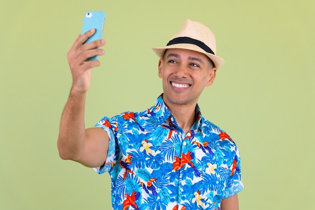 Bel homme de touriste multiethnique contre un mur de couleur