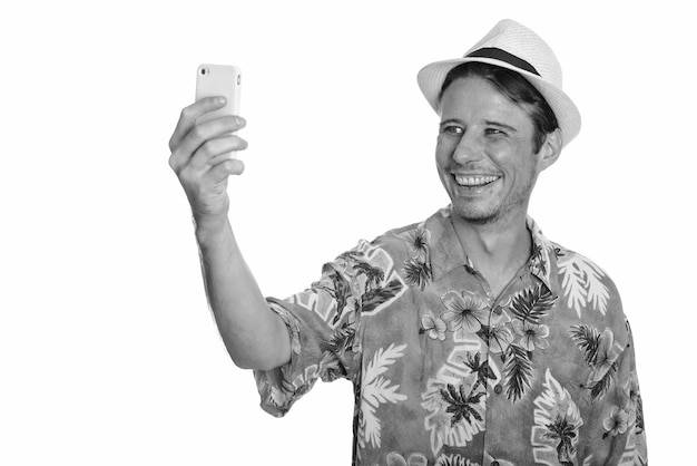 Bel homme de touriste portant chemise hawaïenne et prêt pour des vacances en noir et blanc