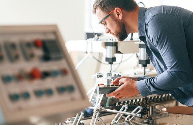 Photo un bel homme travaille dans l'usine de création d'éco-boîtes.