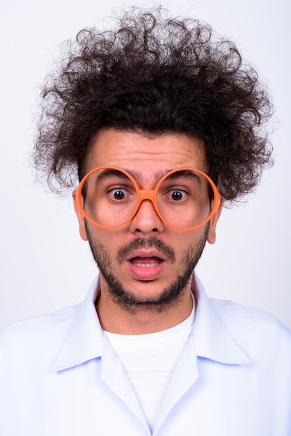 Photo bel homme turc médecin aux cheveux bouclés contre le mur blanc