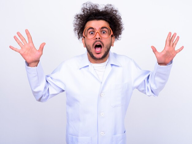 Photo bel homme turc médecin aux cheveux bouclés contre le mur blanc