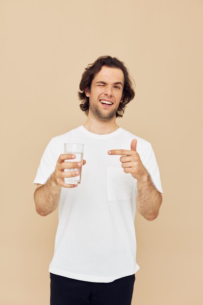 Bel homme verre d'eau dans ses mains émotions posant fond isolé