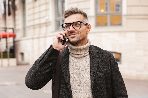 Bel Homme Vêtu D'un Manteau Marchant à L'extérieur, Parler Au Téléphone Mobile