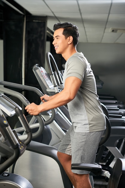 Bel homme vietnamien dans la salle de gym