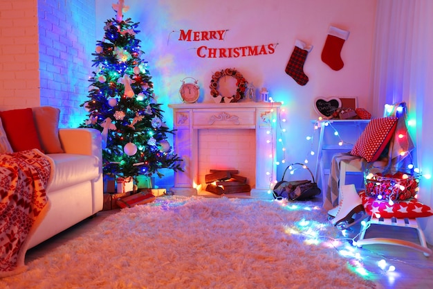 Bel intérieur de Noël avec canapé, cheminée décorative et sapin