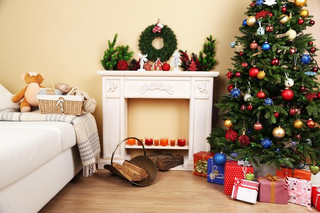 Bel intérieur de Noël avec canapé, cheminée décorative et sapin