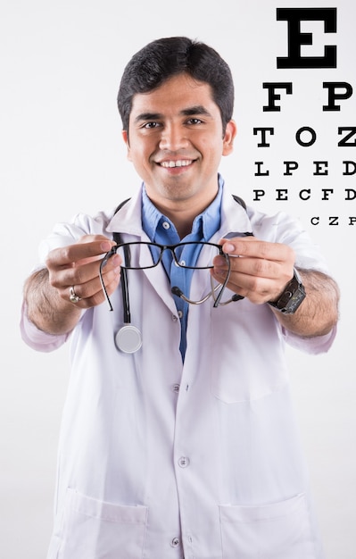 Photo bel ophtalmologiste indien ou optométriste ou spécialiste des yeux, présentant des verres numérotés, isolés sur fond blanc