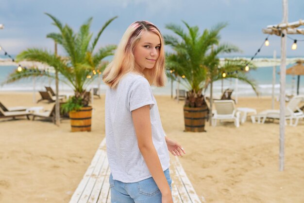 Belle adolescente blonde modèle sur la plage du soir