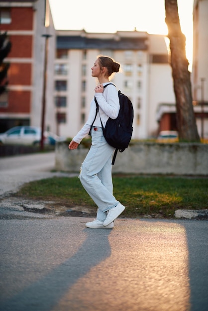 Une belle adolescente européenne capturée dans un portrait de profil latéral rentre à la maison au coucher du soleil après