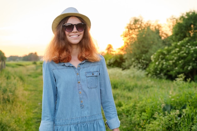 Belle adolescente en jeans robe chapeau, arrière-plan paysage pittoresque, beauté, nature, espace copie