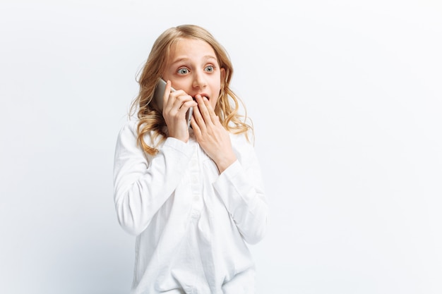 Belle adolescente parlant sur téléphone mobile, la jeune fille sous le choc des nouvelles