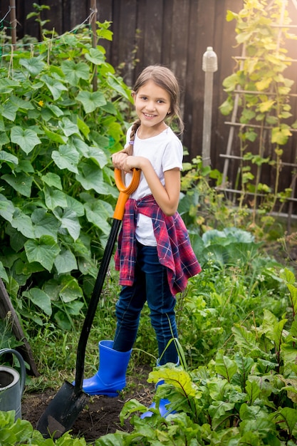 Belle adolescente posant au jardin avec une pelle