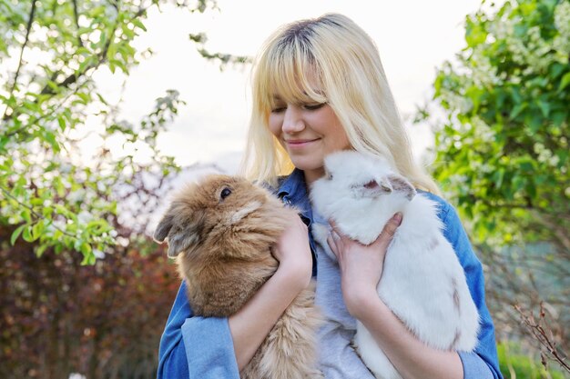 Photo belle adolescente souriante avec un couple de lapins décoratifs