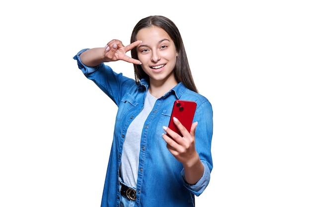 Belle adolescente souriante avec smartphone regardant la caméra