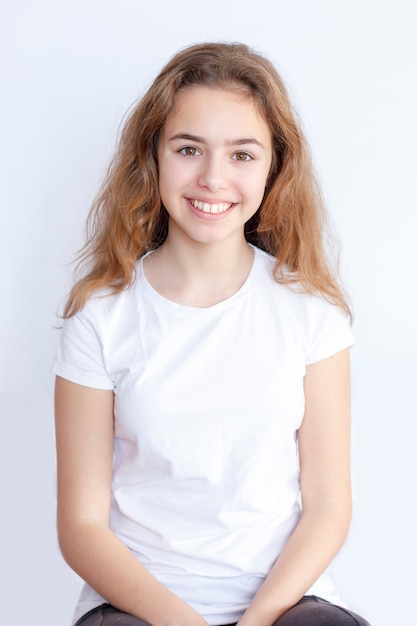 Belle adolescente en t-shirt blanc souriant à la caméra