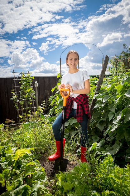 Belle adolescente travaillant au jardin au jour ensoleillé lumineux