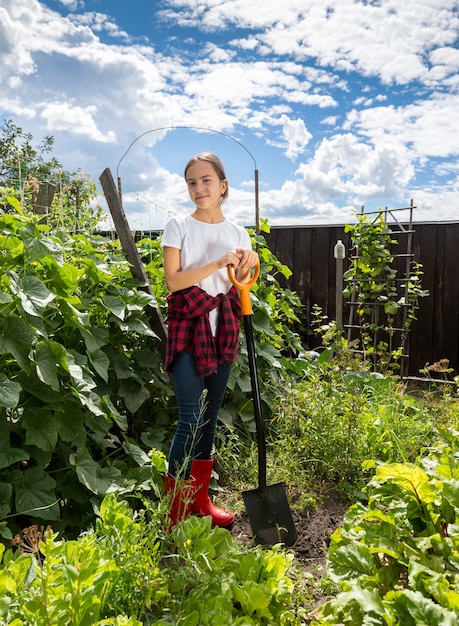 Belle adolescente travaillant sur le jardin à la ferme au jour ensoleillé