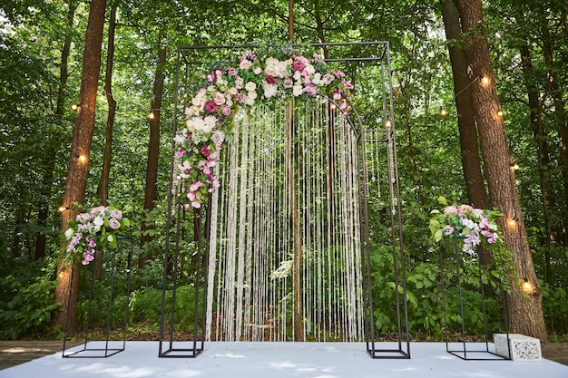 Belle arche de mariage pour cérémonie de style rustique située en forêt