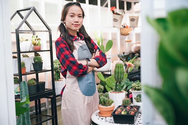 Belle Asie propriétaire petite femme d'affaires au petit magasin cactus