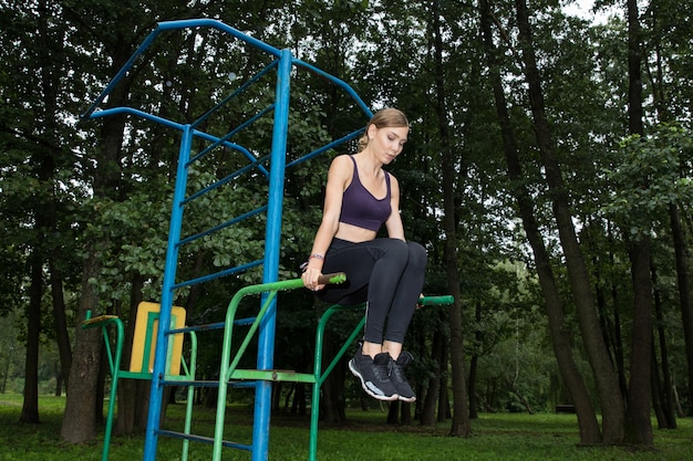 Belle athlète faisant des exercices sur les muscles abdominaux dans le parc