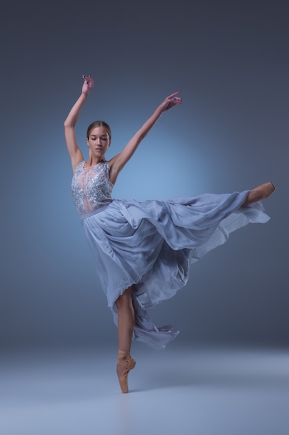 La belle ballerine dansant en robe longue bleue