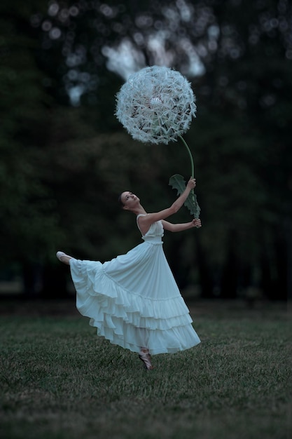 Photo belle ballerine avec des fleurs de pissenlits géantes