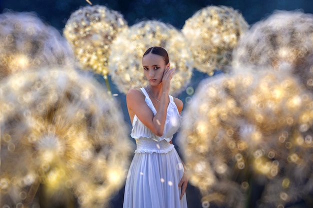 Photo belle ballerine avec pissenlits géants et lumières