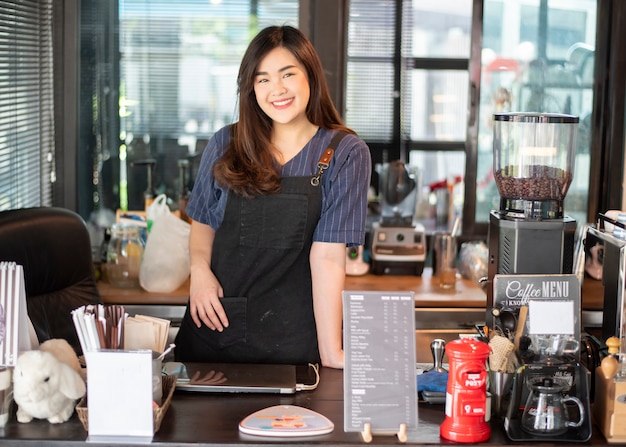 Belle barista sourit dans son café