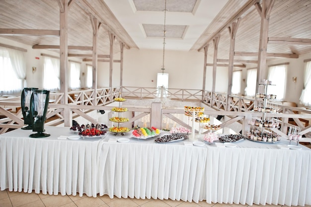 Belle barre chocolatée de mariage avec des bonbons, des fruits et de la nourriture Table de banquet de mariage