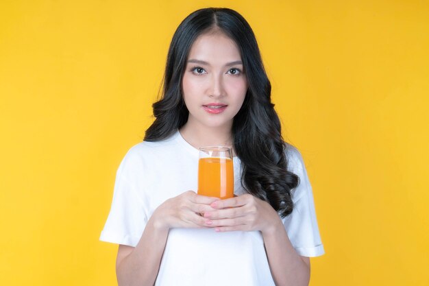 Belle beauté femme asiatique jolie fille se sentir heureuse de boire du jus d'orange pour une bonne santé sur fond blanc - concept sain de femme de beauté de mode de vie