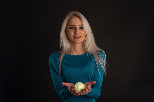 Belle Blonde Dans Une Robe Bleue Avec Une Balle De Tennis