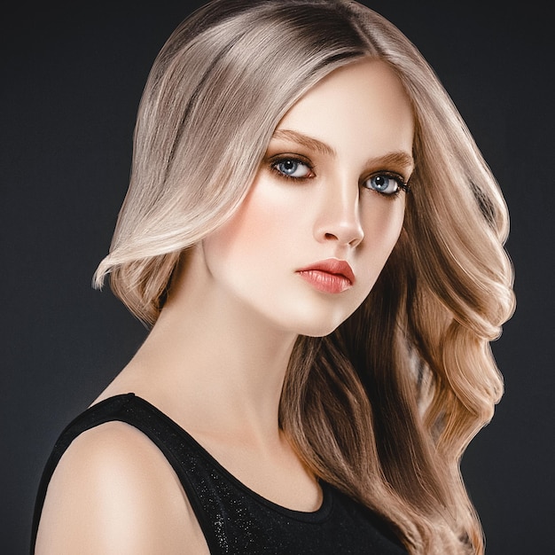 Belle blonde femme modèle de beauté fille avec un maquillage et une coiffure parfaits sur fond noir.