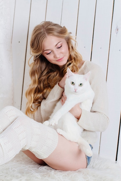 Belle blonde sexy assise avec le chat